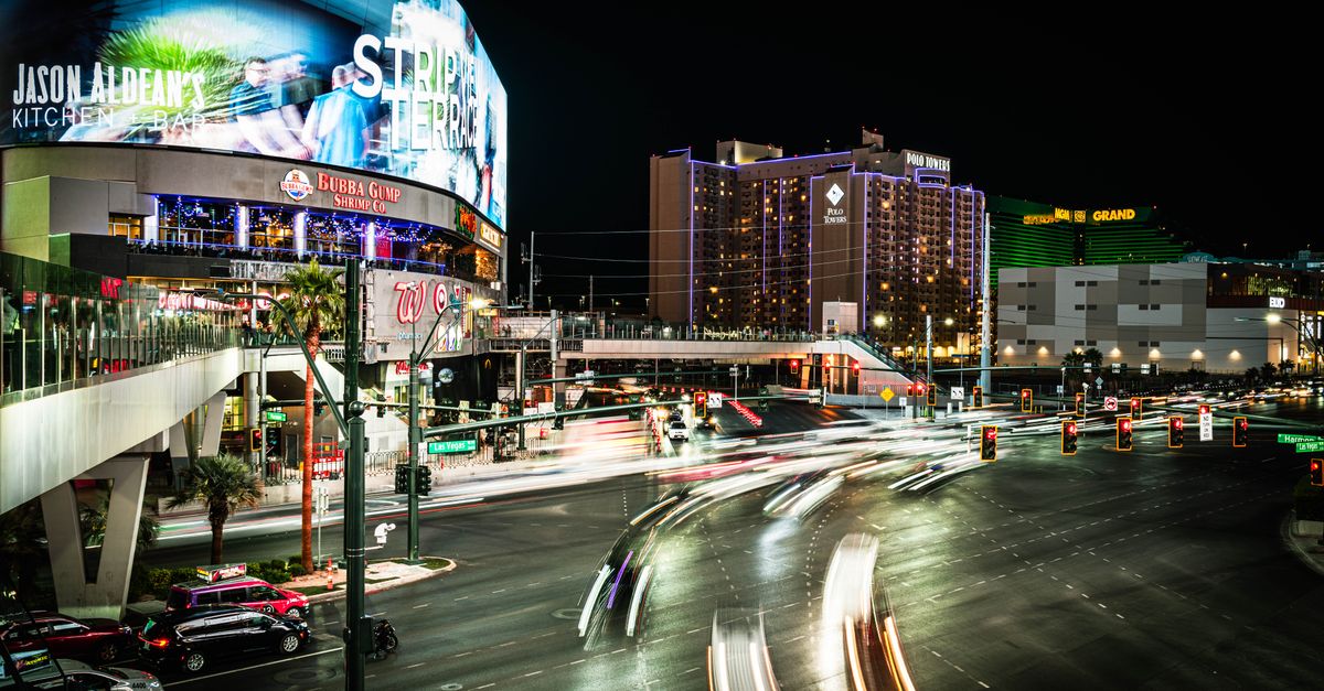 Dynamic night scene on the Las Vegas Strip featuring vibrant lights and busy intersections.